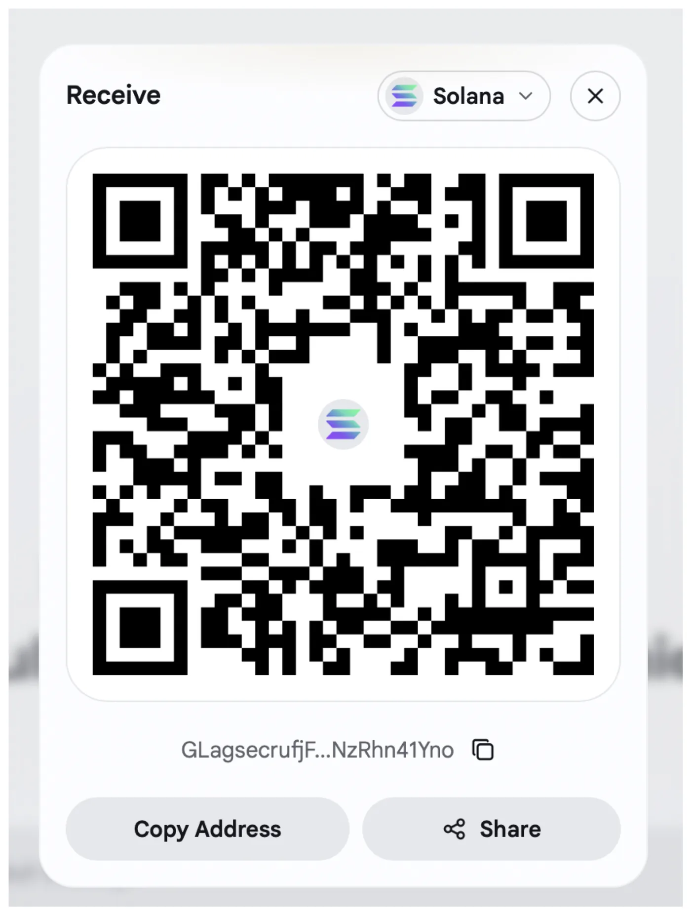 Receive Solana screen with a QR code, truncated wallet address, Copy Address and Share buttons.
